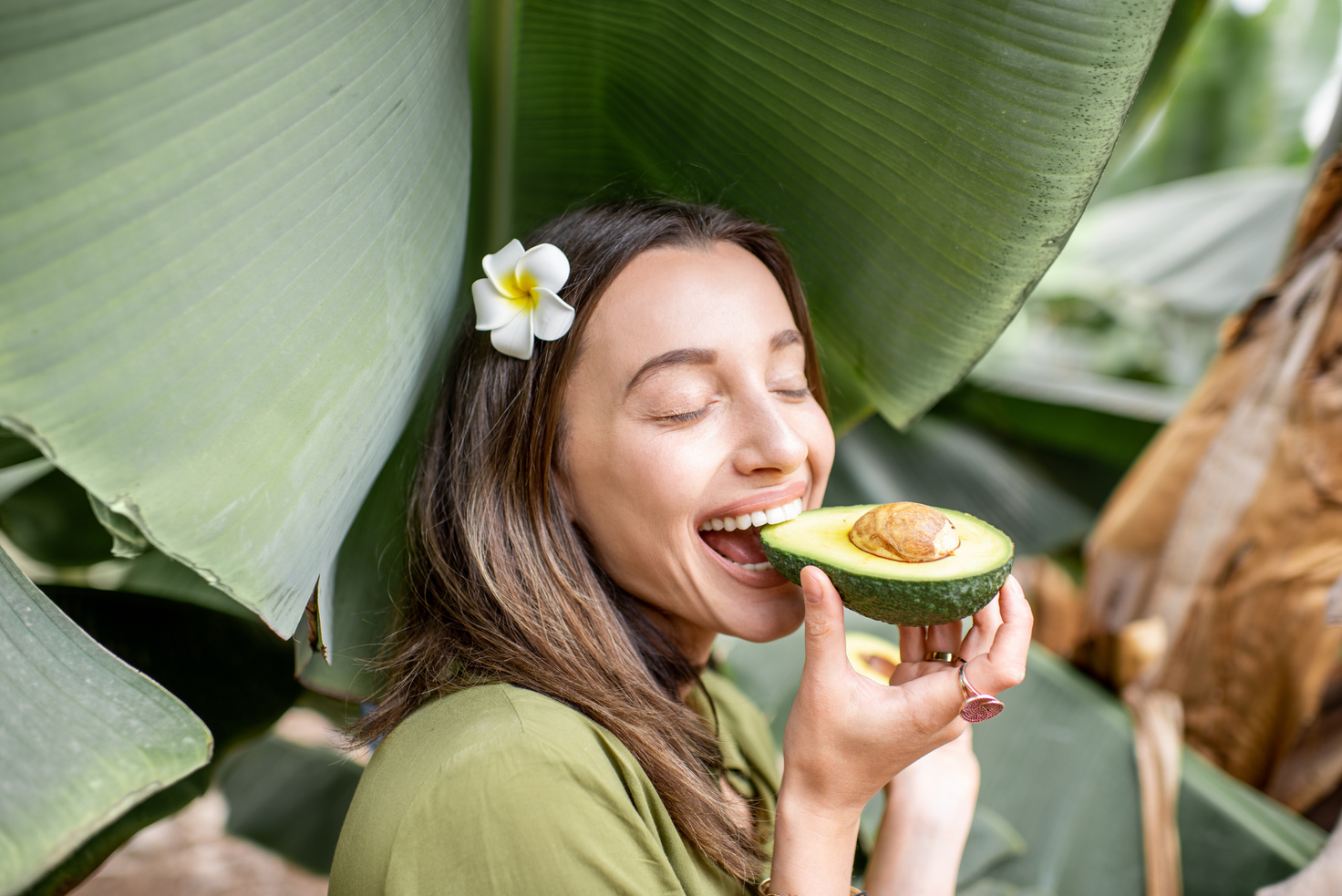 Woman Eating Avocado in Banana Leaves
