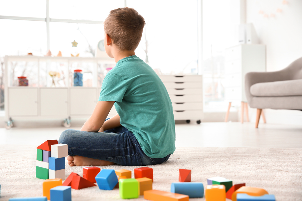 Little Autistic Boy Playing with Cubes at Home
